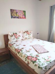 a bedroom with a bed with a floral bedspread at Résidesnce Merveilles Studio in Kribi +24 photos