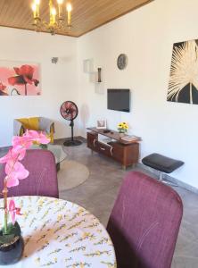 a living room with purple chairs and a table at Résidesnce Merveilles Studio in Kribi