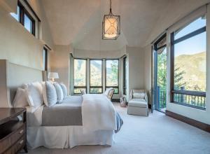 une chambre avec un grand lit et de grandes fenêtres dans l'établissement Little Cloud by Rove 10-Acre Hot Tub Patio, à Aspen