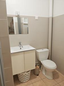 a bathroom with a toilet and a sink and a mirror at Enjoy Studio in Pointe-Noire
