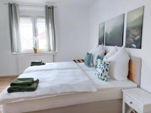 ein Schlafzimmer mit einem großen weißen Bett und Kissen in der Unterkunft Platz für Gruppen - 4 Schlafzimmer mit TV in Ulm