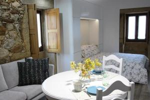 a living room with a table and a bed at Casinha Pousafoles in Arouca