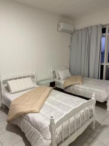 a bedroom with two beds and a window at Departamento Resistencia Centro in Resistencia