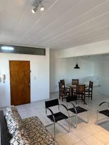 a living room with a table and chairs and a wooden door at Departamento Resistencia Centro in Resistencia