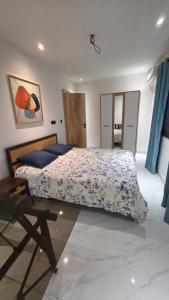 a bedroom with a bed and a table in it at F3 2 Chambres Piscine Residence Point E in Dakar +24 photos