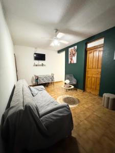 a living room with a bed and a tv at L'herbe à pic. in Les Abymes