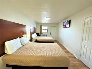 a hotel room with two beds and a window at Budget Inn Giddings in Giddings