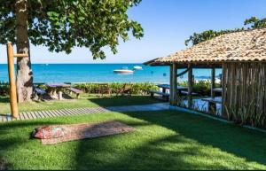 um jardim com um gazebo e o oceano em Casa Mar em Porto Seguro
