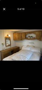 a bedroom with a bed with white sheets and a mirror at CSS butlins Skegness retreat in Skegness