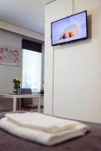 a room with a tv hanging on a wall at Railway&bus station studio, parking in Oulu