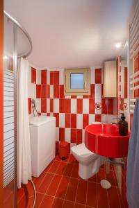 une salle de bain rouge et blanche avec des toilettes et un lavabo dans l'établissement Traveler Home 85m2 Private Parking Next to Center, à Thessalonique