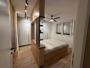 a small bedroom with a bed and a black book shelf at Central Spot BL in Banja Luka
