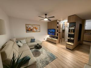 a living room with a couch and a tv at Central Spot BL in Banja Luka