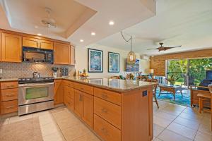 a large kitchen with wooden cabinets and a dining room at Kahana Sunset B4B in Lahaina