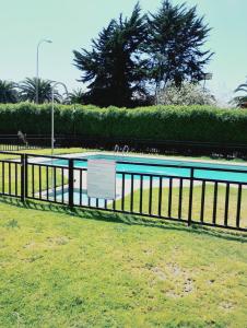 a fence with a sign next to a swimming pool at Cómodo y espacioso departamento en La Serena in La Serena