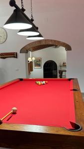 ein roter Billardtisch in einem Wohnzimmer mit einer Uhr in der Unterkunft Charming Guest Room in Villa Casavecchia in Dicomano