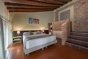 a bedroom with a bed and a brick wall at Villa D&D in Parma