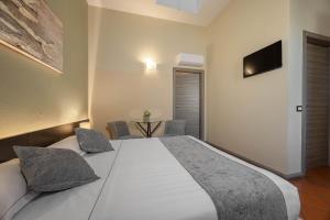 a bedroom with a large white bed and a table at Villa D&D in Parma