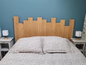 1 cama con cabecero de madera y 2 mesitas de noche en Le Gemmois, en Sainte-Gemme-sur-Loire
