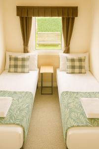 阿伯里斯特威斯Welsh Seaview Stay 3 bed caravan by pool, club and beach的有窗户的房间里有两张床