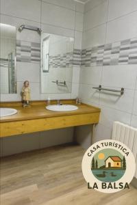 a bathroom with two sinks and a mirror at La Balsa in Matalebreras +11 photos