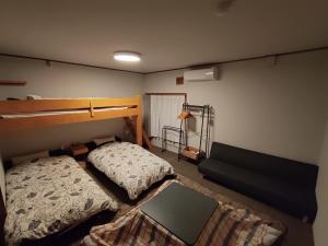een slaapkamer met 2 stapelbedden en een bank bij Mountain Jam in Kutchan
