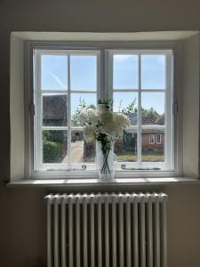 a vase of white flowers sitting on a window sill at The Old Forge in Wendover +9 photos