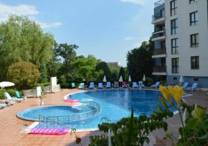 a large swimming pool with chairs and a building at Amphora Palace Apartment Complex in Golden Sands