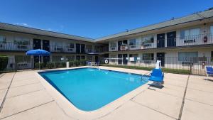 una piscina frente a un edificio de apartamentos en Motel 6-Conroe, TX, en Conroe