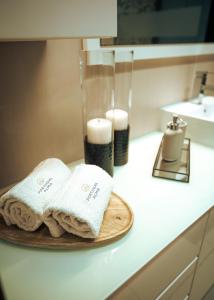 a bathroom with two towels on a plate on a counter at Portugal Alma - Oporto Guesthouse in Ermesinde