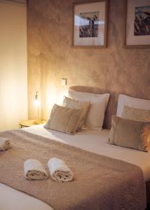 a bedroom with a large bed with two towels on it at Portugal Alma - Oporto Guesthouse in Ermesinde +60 photos