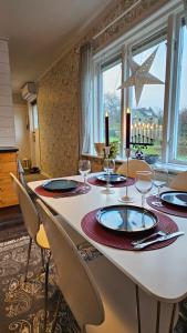 a dining room table with chairs and a large window at Little Cabin in Gnosjö