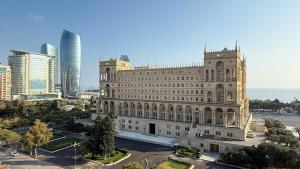een oud gebouw in een stad met hoge gebouwen bij Sea view luxury in Baku