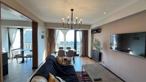 een woonkamer met een bank en een flatscreen-tv bij Sea view luxury in Baku