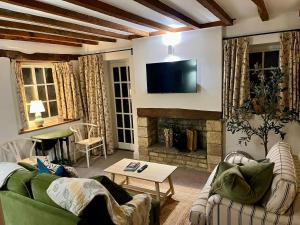 a living room with a couch and a fireplace at The Carriage House in Blockley
