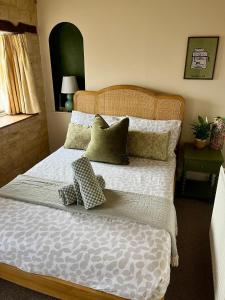 ein Schlafzimmer mit einem großen Bett mit Kissen darauf in der Unterkunft The Carriage House in Blockley