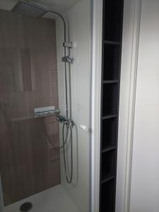 a shower with a hose hooked up to a glass door at chalet de 1 a 7 personnes in Hermanville-sur-Mer +6 photos