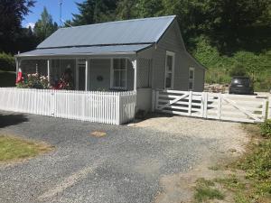 een klein grijs huis met een wit hek bij Hollywood's Folly in Lawrence