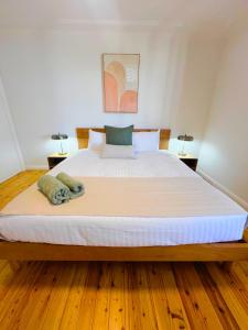 a bedroom with a large white bed with two lamps at Prickly Pear Stays in Merewether - Ranclaud St in Merewether