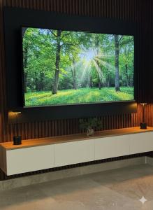 a television screen with a picture of a forest at 3BR 5Bed luxury apartment in Jeddah
