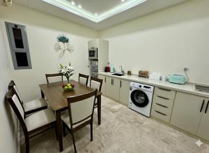 a kitchen with a table and chairs and a washing machine at AL Rayan Luxury Apartments in Jeddah