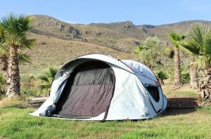 a tent sitting in a field with palm trees at Parcela autocaravana o tienda propia - Wellnesscamp Oasis Al Hamam in Lucainena de las Torres