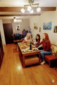 three women sitting around a table with glasses of wine at ゲストハウス海と石 in Takamatsu