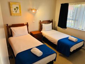 パーマストンノースにあるAwatea Park Motelのベッドが2つと窓のある部屋