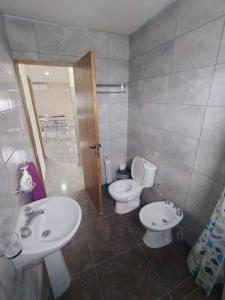 a bathroom with two toilets and a sink at Apart Cuyo in San Rafael