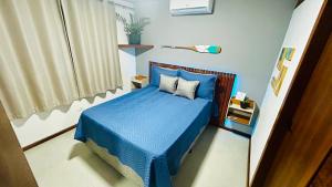 a small bedroom with a blue bed with blue sheets at JanHouse Ilhabela in Ilhabela