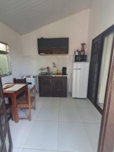 cocina con mesa, nevera y mesa en Verde Mar Inn, en Angra dos Reis