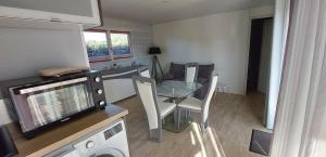 a small kitchen with a glass table and a dining room at chalet de 1 a 7 personnes in Hermanville-sur-Mer