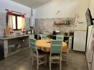 a kitchen with a table with chairs and a refrigerator at La posada de Rufina in Reyes