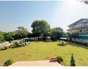 une grande cour avec des tables et des parasols et un bâtiment dans l'établissement Baani signature, à Islamabad